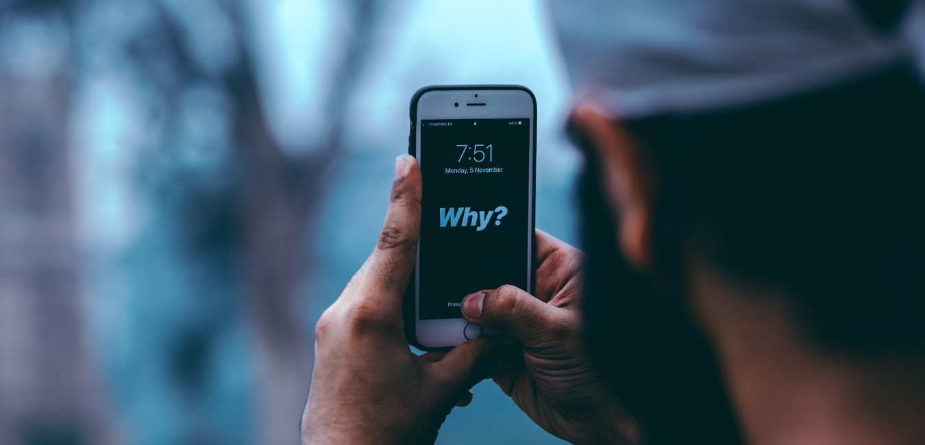 Was ist deine Motivation für das Studium? Mann mit Handy mit "Why?" im Bildschirm. 