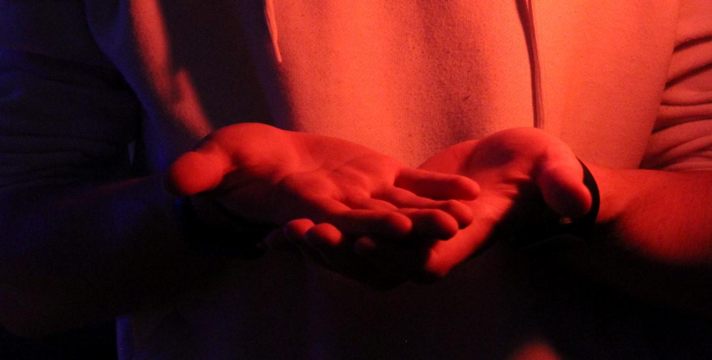 Zwei Hände im rot blau Licht. by Nick on Unsplash